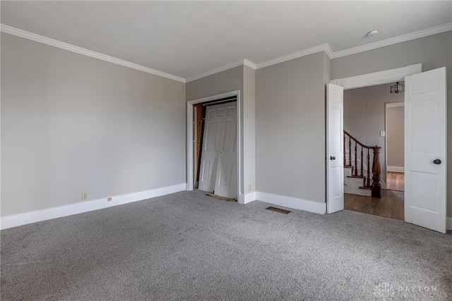 unfurnished bedroom with carpet, visible vents, crown molding, and baseboards