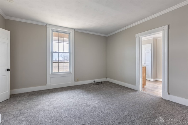 unfurnished room featuring ornamental molding, carpet flooring, and baseboards