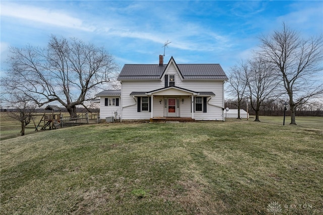 view of front of property with metal roof, a chimney, and a front yard