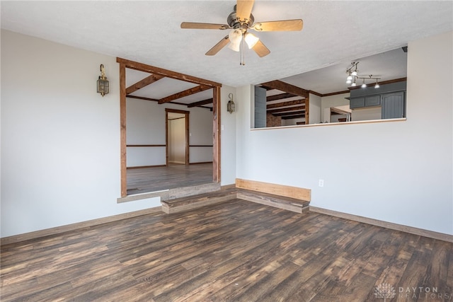 unfurnished room with a textured ceiling, wood finished floors, and baseboards