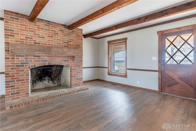 unfurnished living room with beam ceiling, wood-type flooring, a fireplace, and baseboards