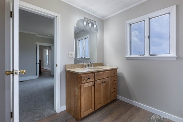 bathroom with ornamental molding, wood finished floors, and baseboards