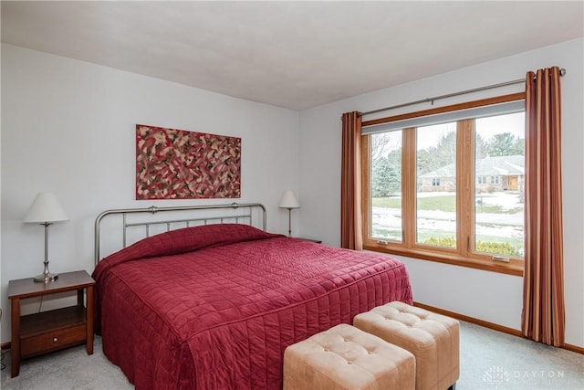 bedroom with baseboards and light colored carpet