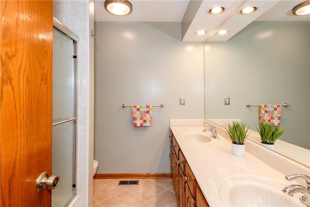 bathroom with tile patterned flooring, visible vents, a sink, and a shower with shower door