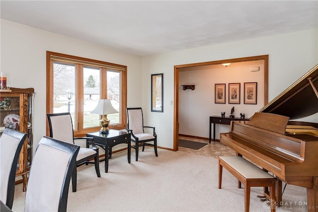 living area featuring light colored carpet and baseboards