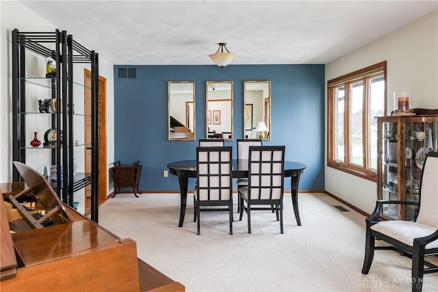 dining room with visible vents, baseboards, and carpet flooring