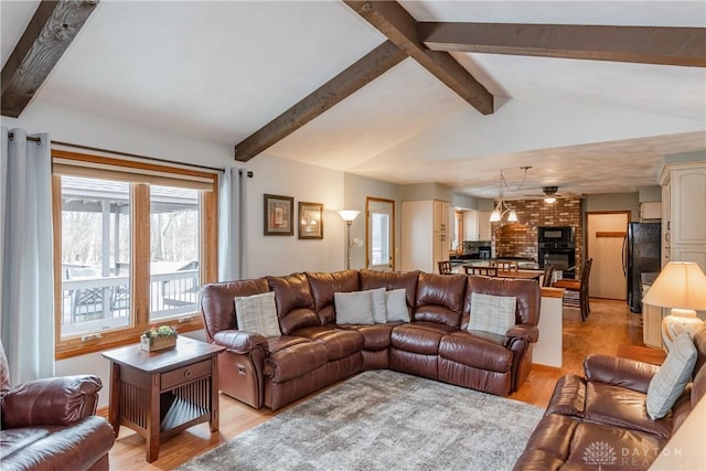 living room featuring vaulted ceiling with beams and light wood finished floors