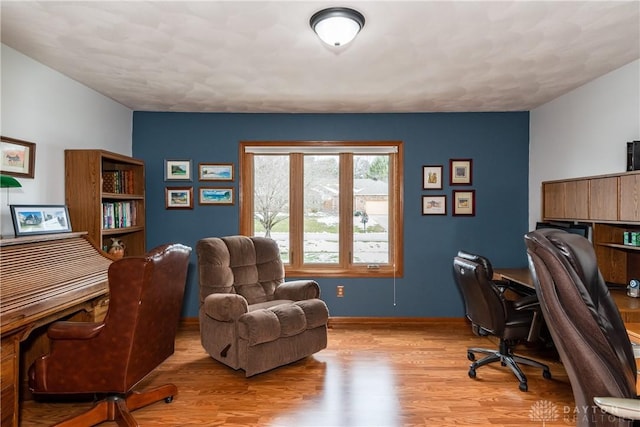 home office featuring baseboards and wood finished floors