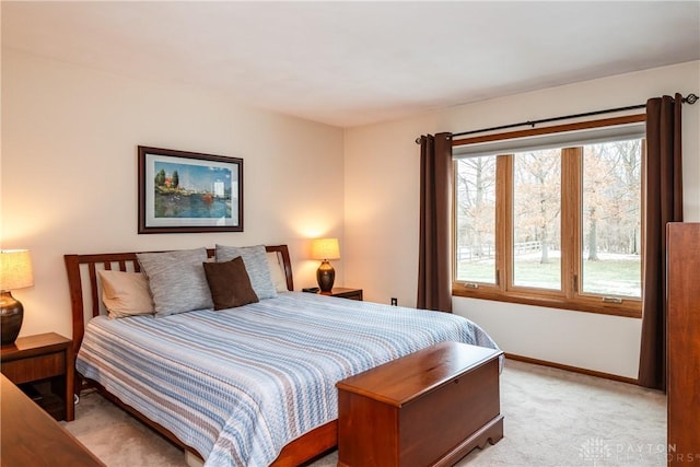 bedroom featuring light carpet and baseboards