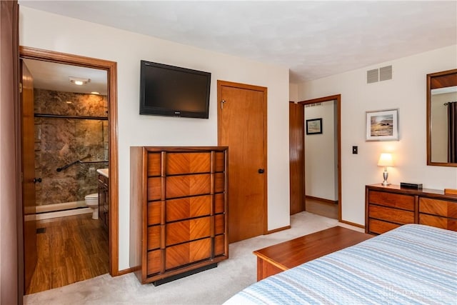 carpeted bedroom with a closet, visible vents, connected bathroom, and baseboards