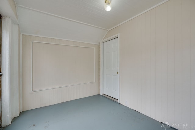 unfurnished room with lofted ceiling and concrete flooring