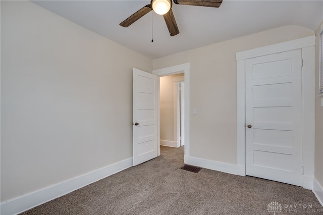 unfurnished bedroom with a ceiling fan, carpet flooring, visible vents, and baseboards