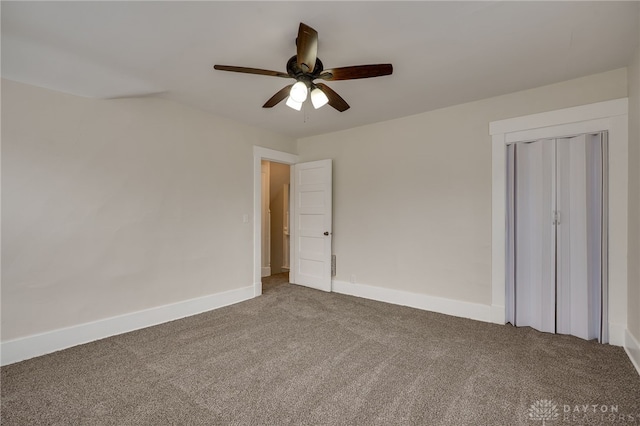 unfurnished bedroom with a ceiling fan, a closet, baseboards, and carpet flooring