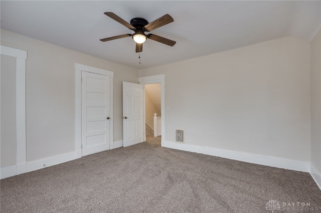 empty room featuring carpet floors, visible vents, ceiling fan, and baseboards