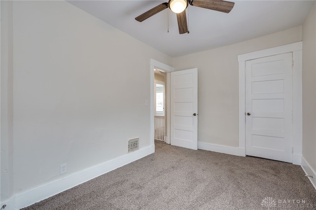 unfurnished bedroom with carpet flooring, ceiling fan, visible vents, and baseboards