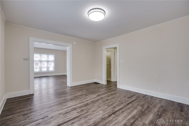 unfurnished room featuring baseboards and wood finished floors