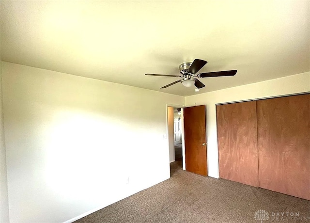 unfurnished bedroom featuring ceiling fan, a closet, and carpet flooring