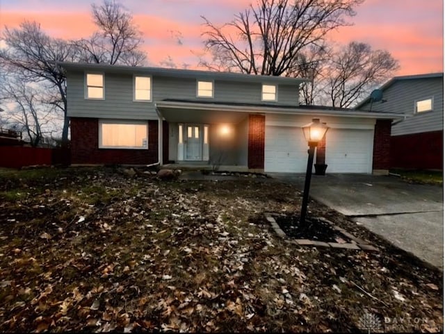 traditional-style home featuring driveway, brick siding, and an attached garage