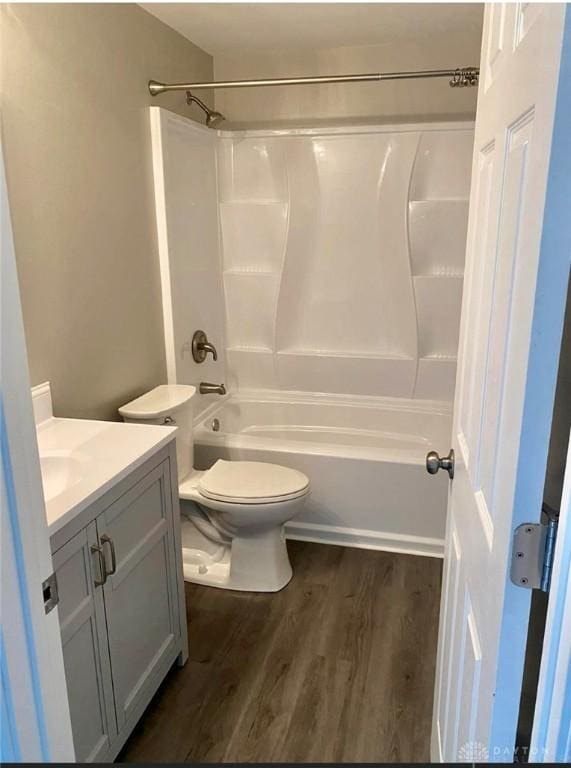 full bathroom featuring toilet, shower / bathing tub combination, wood finished floors, and vanity