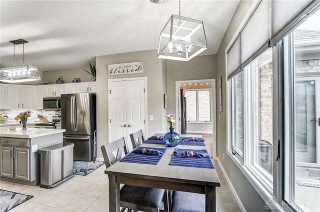 dining room featuring light tile patterned floors, baseboards, and an inviting chandelier