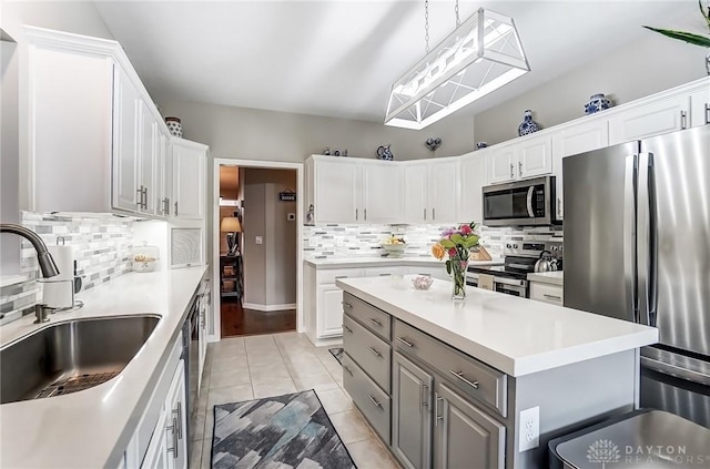 kitchen with stainless steel appliances, light countertops, a sink, and white cabinetry