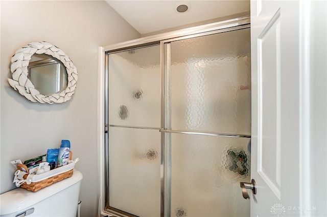 bathroom with a shower stall and toilet