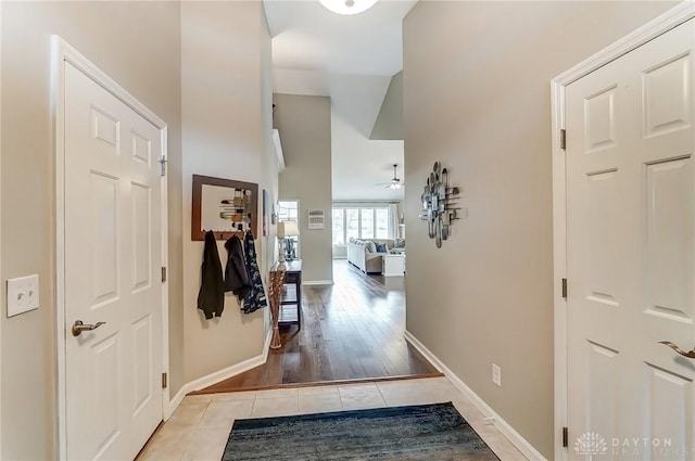 corridor with light tile patterned floors and baseboards