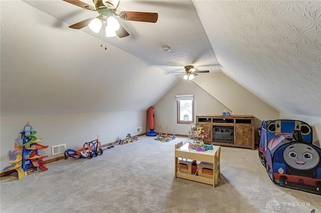 rec room with carpet, lofted ceiling, visible vents, a textured ceiling, and baseboards