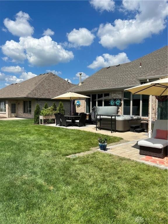 rear view of house featuring a patio, roof with shingles, a yard, outdoor lounge area, and brick siding