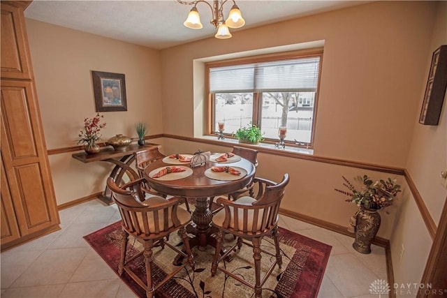 dining room featuring light tile patterned floors, baseboards, and an inviting chandelier