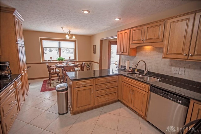 1250 Yankee Woods Dr, Washington Twp, OH 45458 - kitchen with stainless steel dishwasher, a sink, a peninsula, a textured ceiling, and plenty of natural light