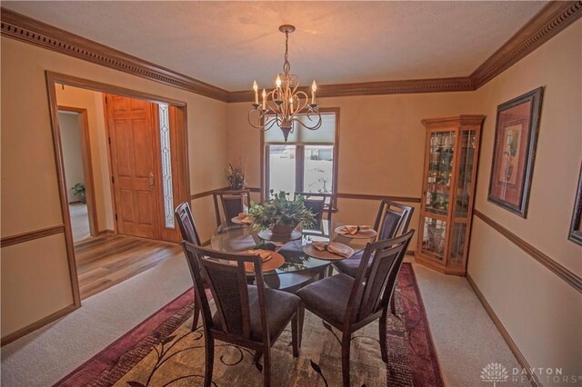 1250 Yankee Woods Dr, Washington Twp, OH 45458 - dining space featuring light colored carpet, a chandelier, ornamental molding, and baseboards