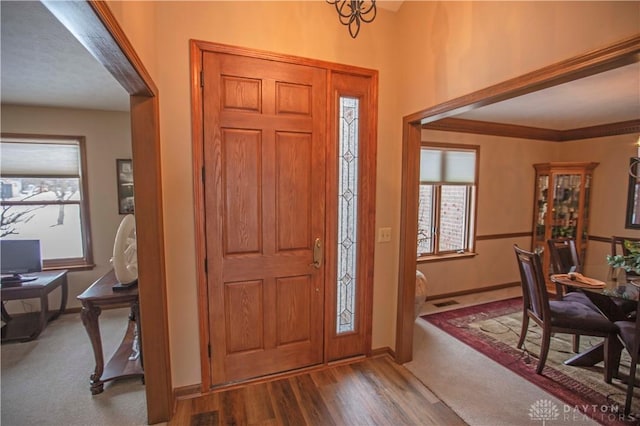 foyer entrance featuring baseboards and wood finished floors