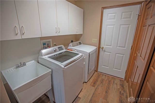 1250 Yankee Woods Dr, Washington Twp, OH 45458 - laundry area with independent washer and dryer, cabinet space, and light wood-style floors
