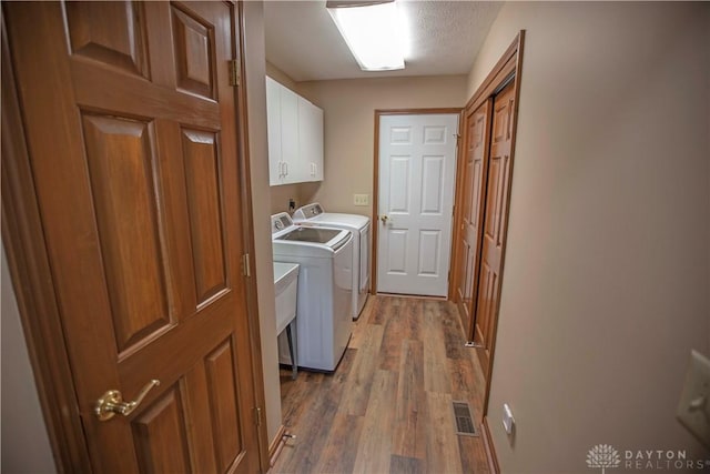 1250 Yankee Woods Dr, Washington Twp, OH 45458 - clothes washing area featuring washer and dryer, cabinet space, and wood finished floors