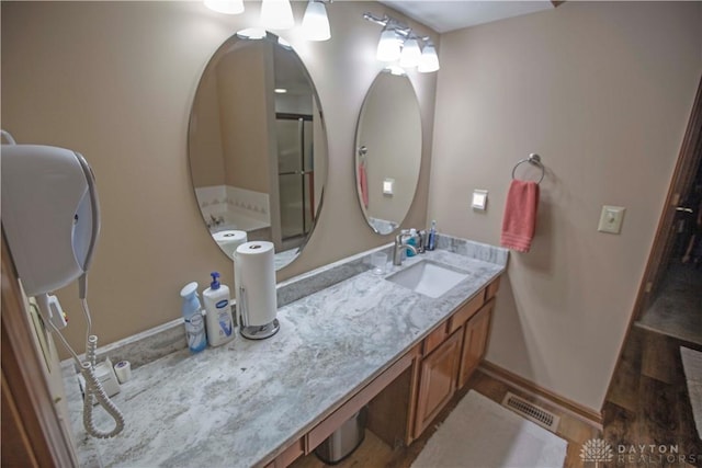 bathroom featuring vanity, visible vents, and baseboards