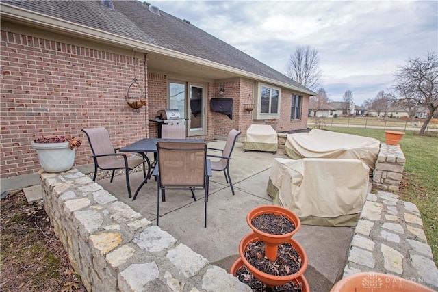 view of patio featuring a grill, fence, and outdoor dining space