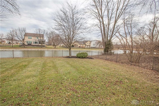 view of yard featuring a fenced backyard and a water view