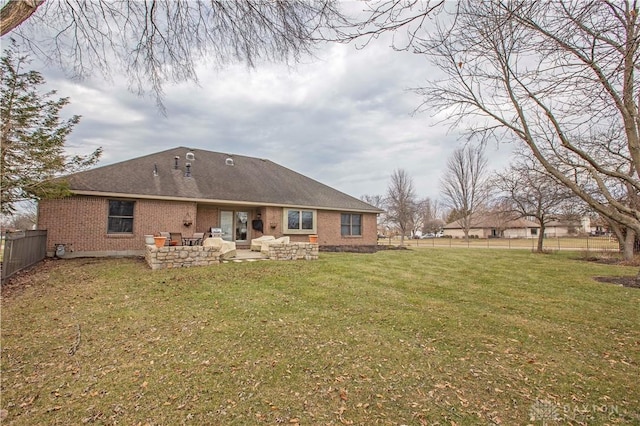 back of house featuring a patio area, brick siding, a lawn, and a fenced backyard