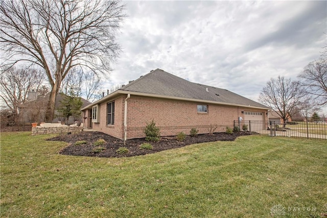 view of side of home featuring a garage, brick siding, fence, and a lawn