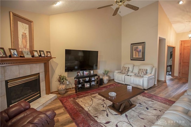 1250 Yankee Woods Dr, Washington Twp, OH 45458 - living area with wood finished floors, a tiled fireplace, high vaulted ceiling, a ceiling fan, and baseboards