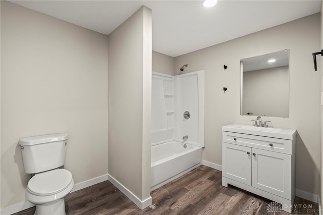 bathroom with toilet, baseboards, wood finished floors, and vanity