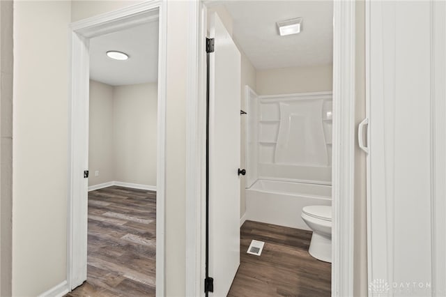 full bath with toilet, tub / shower combination, wood finished floors, and visible vents