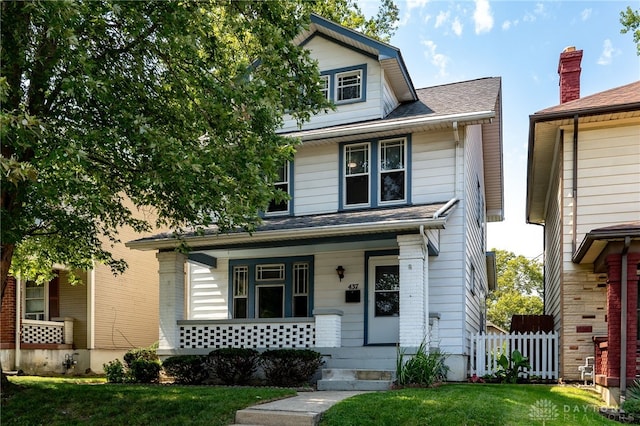 view of front of property with a porch, a front yard, and fence