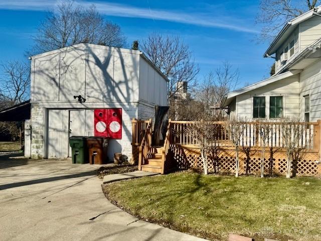 exterior space with a garage, driveway, a deck, and a yard