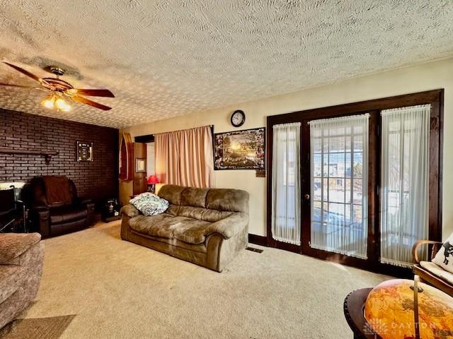 carpeted living room with a textured ceiling and a ceiling fan