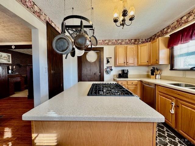 kitchen with a textured ceiling, a kitchen island, light countertops, and dishwasher