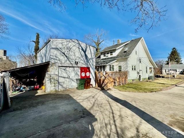 view of side of property with a barn, driveway, a garage, an outbuilding, and a carport