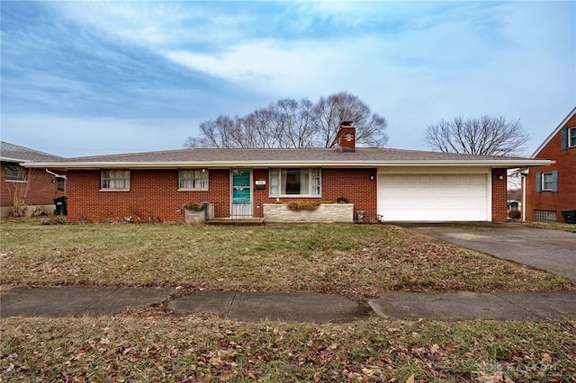 ranch-style home featuring brick siding, a chimney, concrete driveway, an attached garage, and a front lawn