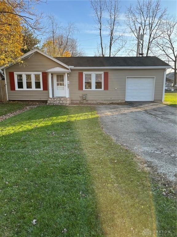 ranch-style house featuring an attached garage, driveway, and a front yard